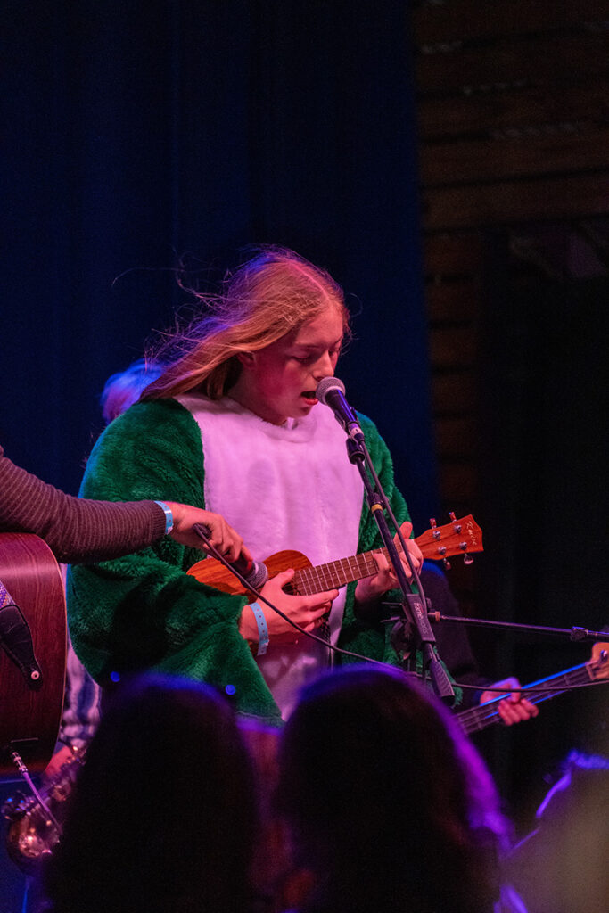 Student playing guitar in mascot outfit at Bennaroo