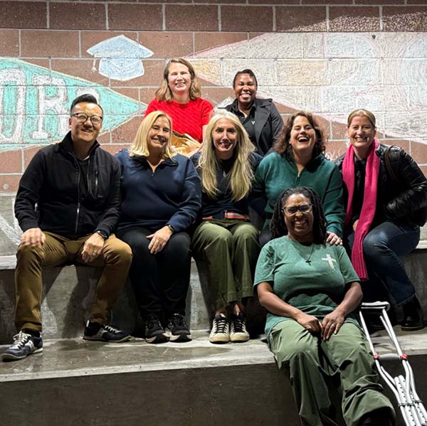 8 adults in front of a graphic wall