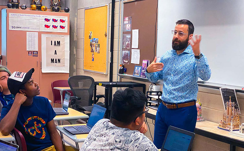 Teacher standing in front of class teaching