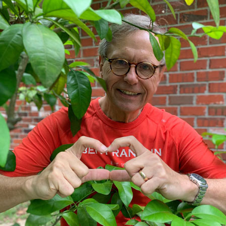 Alumni Director John Parauka making a heart symbol with his hands