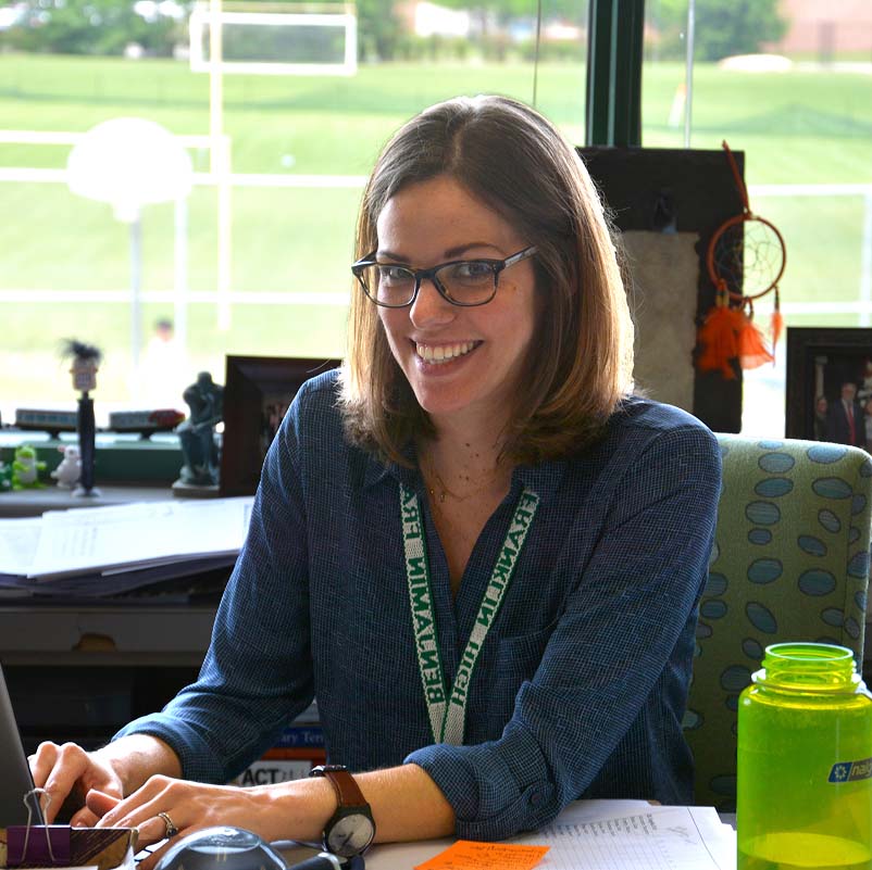 Ms. Amanda Morehouse smiling from her desk
